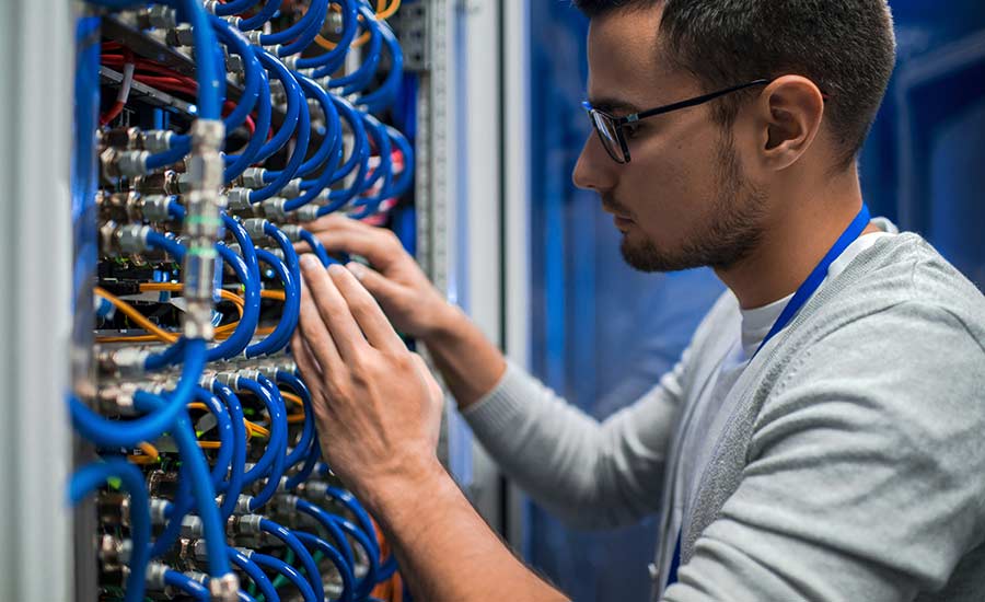 A young man repairs cable equipment