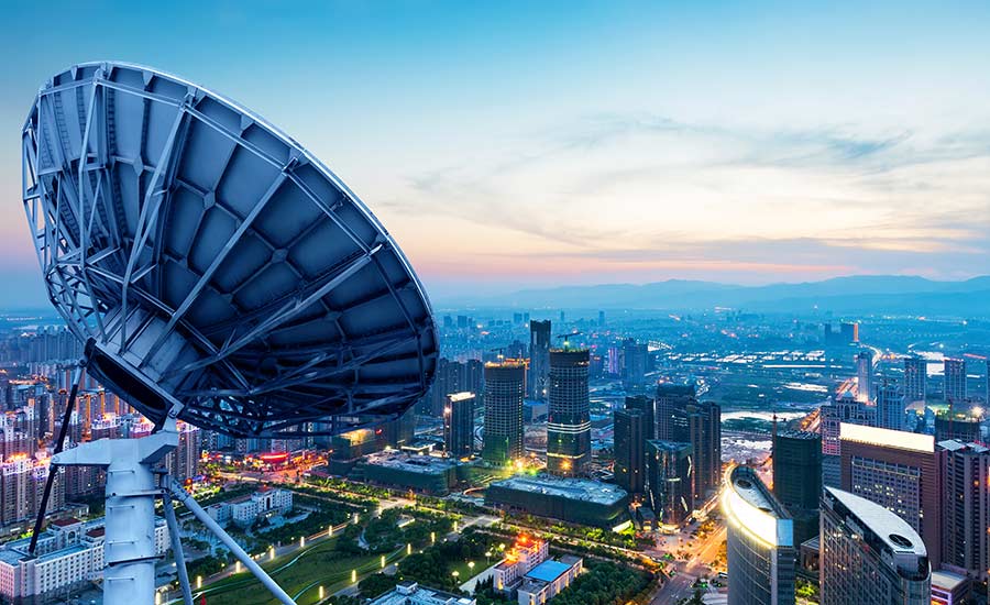 A satellite dish, with a city view in the background